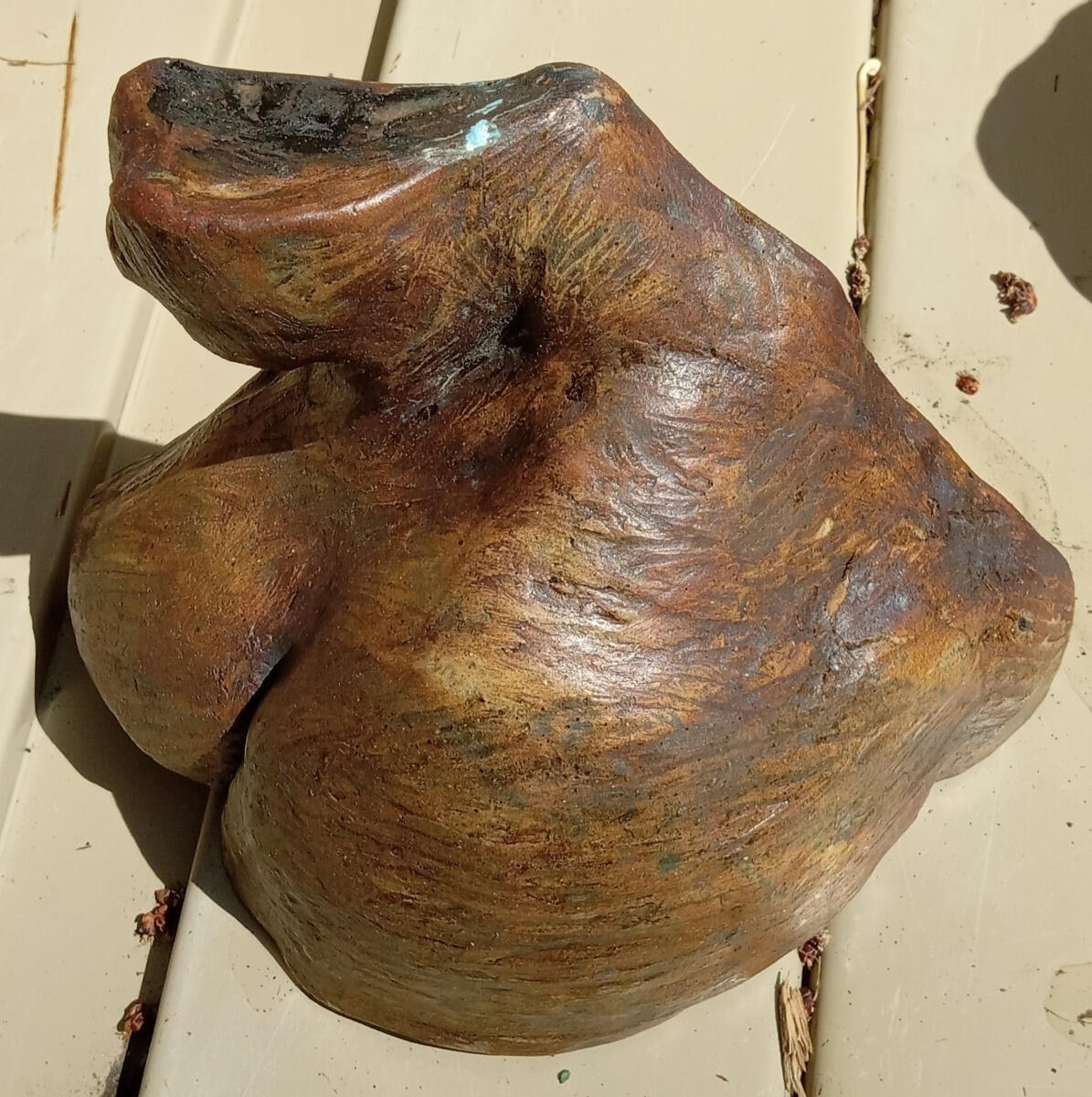 Ceramic sculptural study (a maquette) of a queer woman's shoulder, neck and breast by Shane Brodie. The sculptor's fingermarks are seen on the surface which is mostly dark brown with a patina of lighter colors.